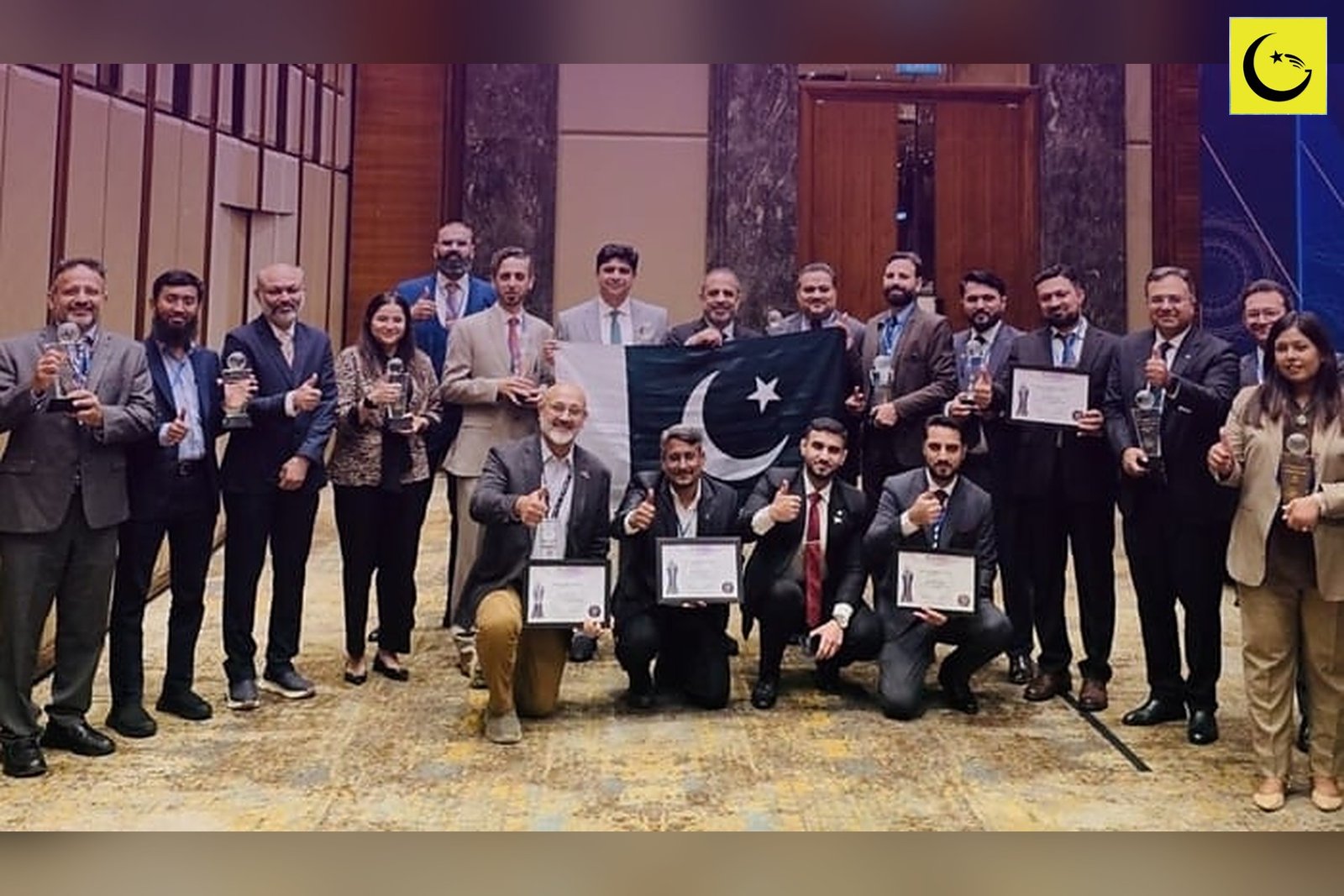 Pakistan ASOCIO awards 2026 winners posing with trophies, certificates and the Pakistani flag at the Jakarta awards night